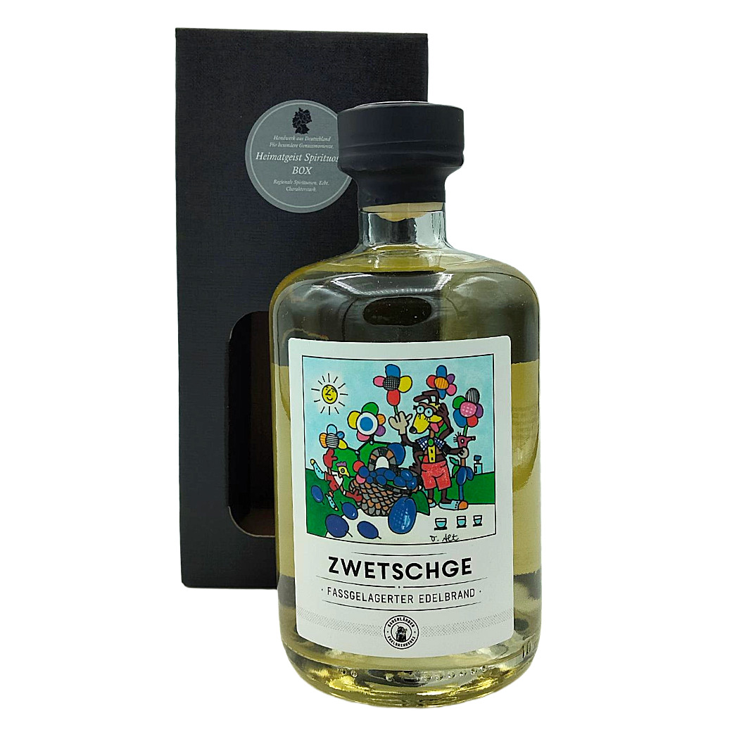 Zwetschgen Edelbrand in dekorativer Flasche, mit buntem Etikett und schwarzer Geschenkverpackung.