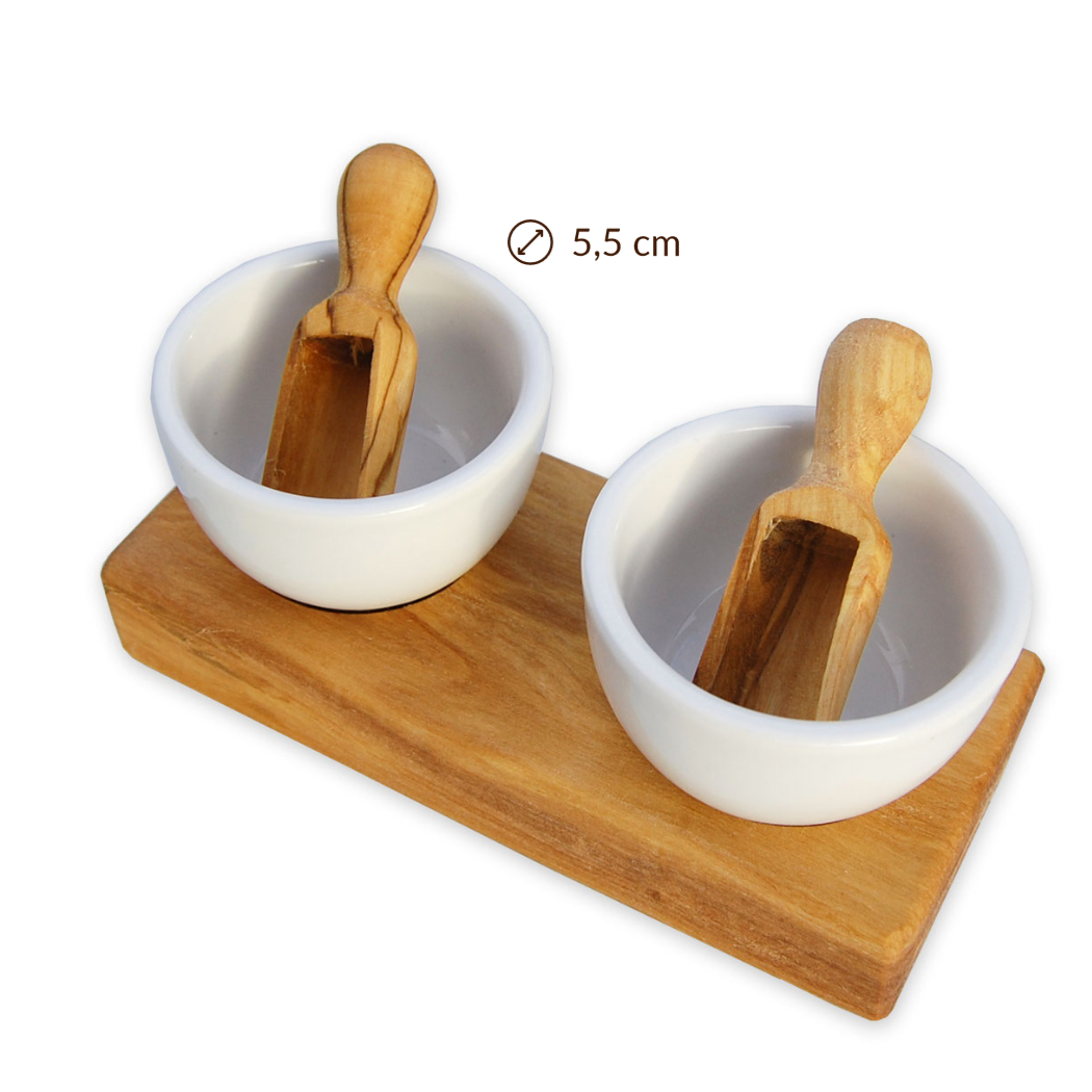 Zwei weiße Schalen aus Keramik mit Holzlöffeln auf einem Holzbrett, Durchmesser 5,5 cm.