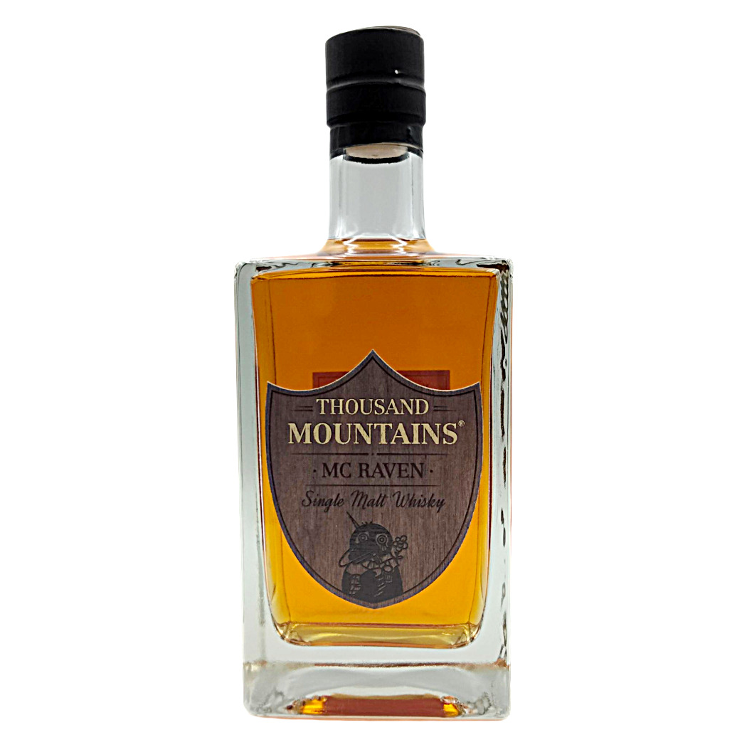 Single Malt Whisky in einer quadratischen Glasflasche mit Holzetikett, bernsteinfarbener Flüssigkeit und schwarzem Verschluss.
