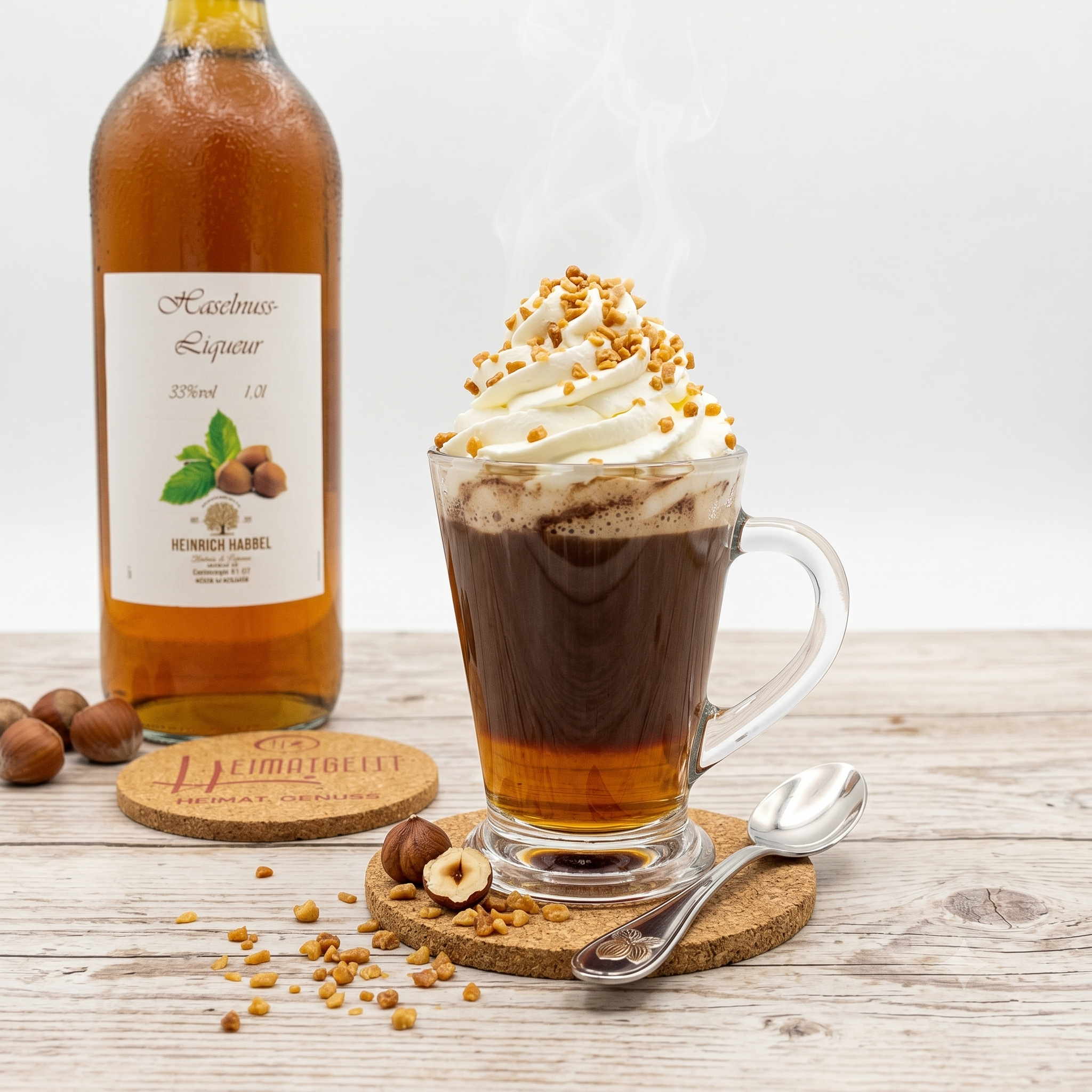 Ein Glas heißen Kaffee mit Schlagsahne und Haselnussstücken, im Hintergrund eine Flasche Haselnusslikör.